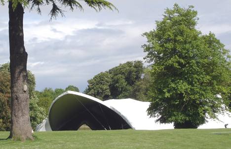 White modular saddle span tent set amongst trees